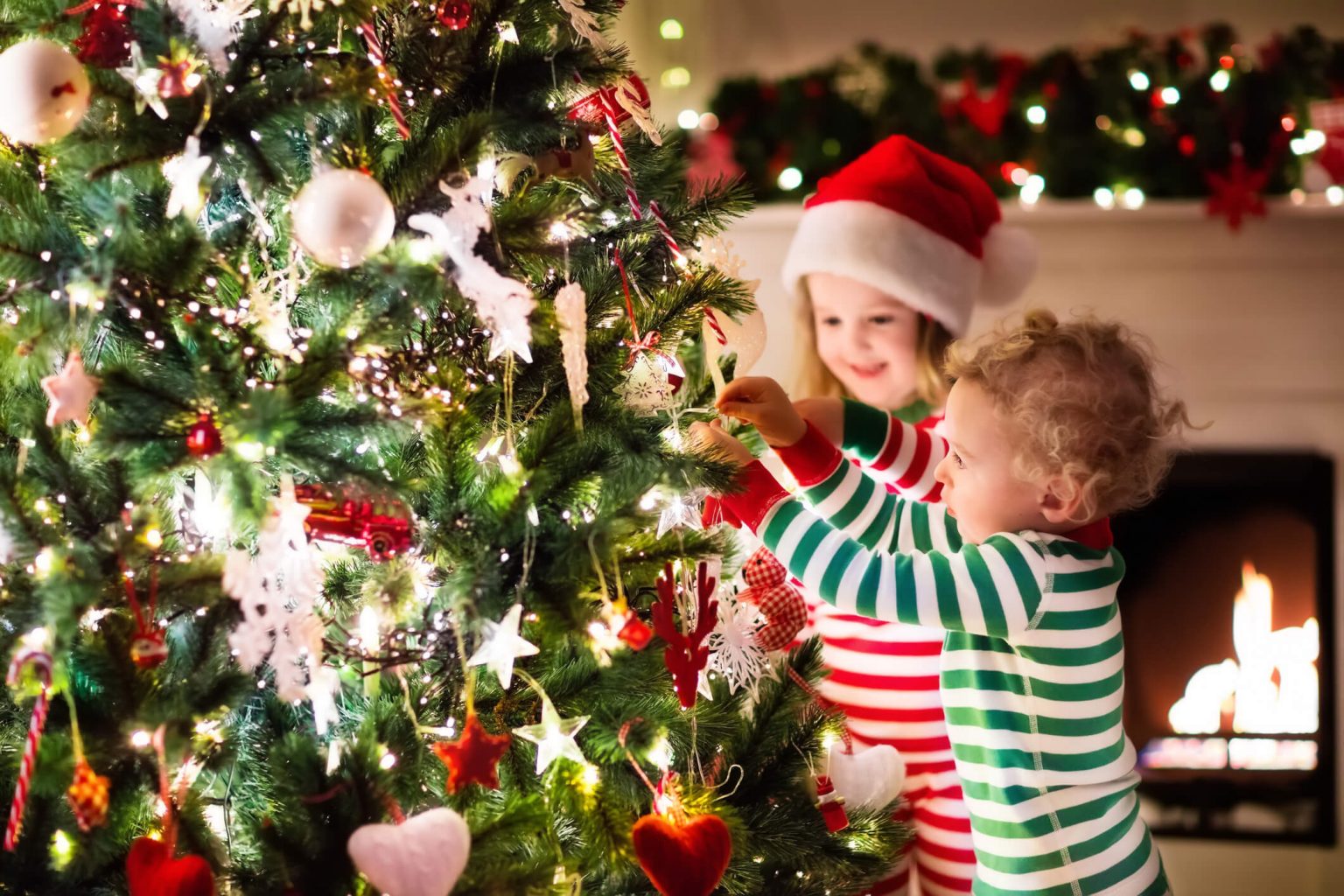 Two kids hanging an ornament