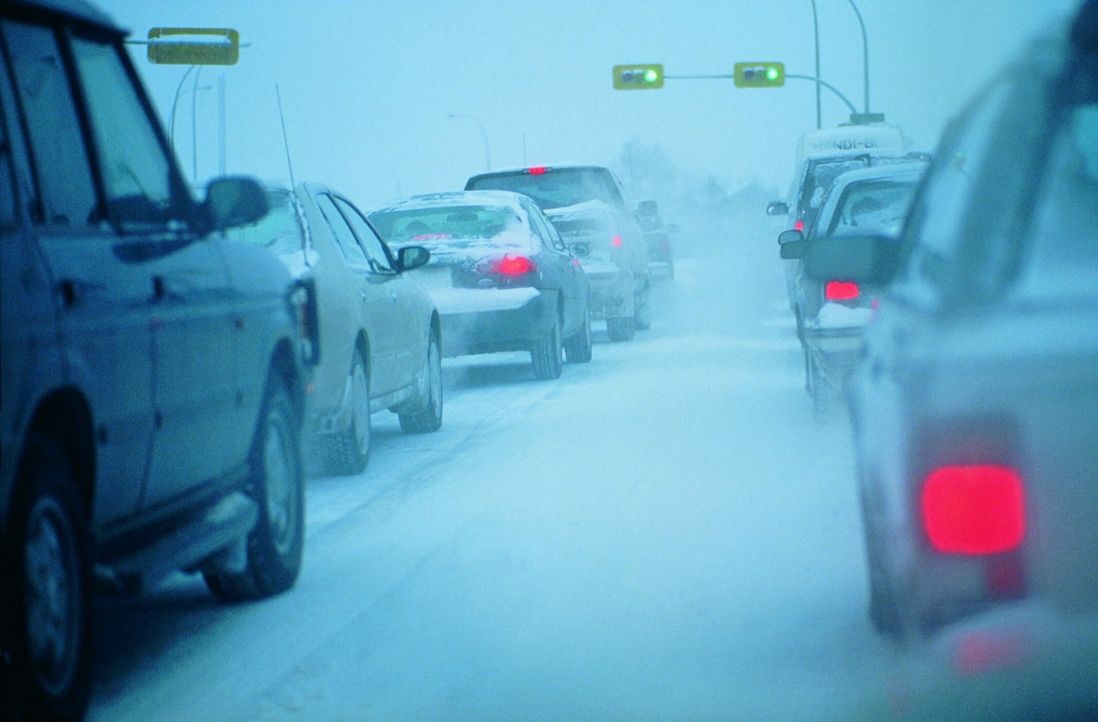 Various cars driving on a wintery road.