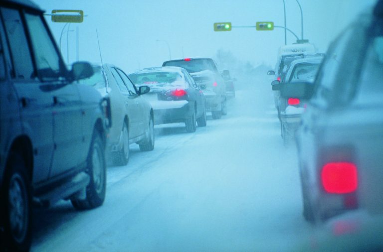 Various cars driving on a wintery road.