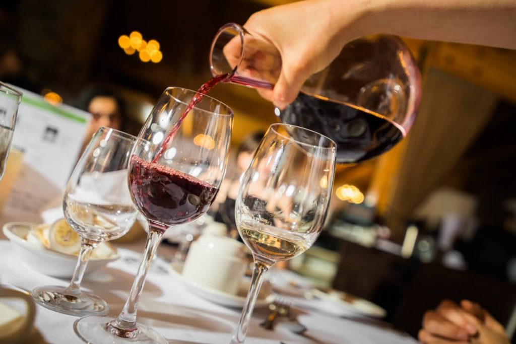 Someone pouring wine into a glass.