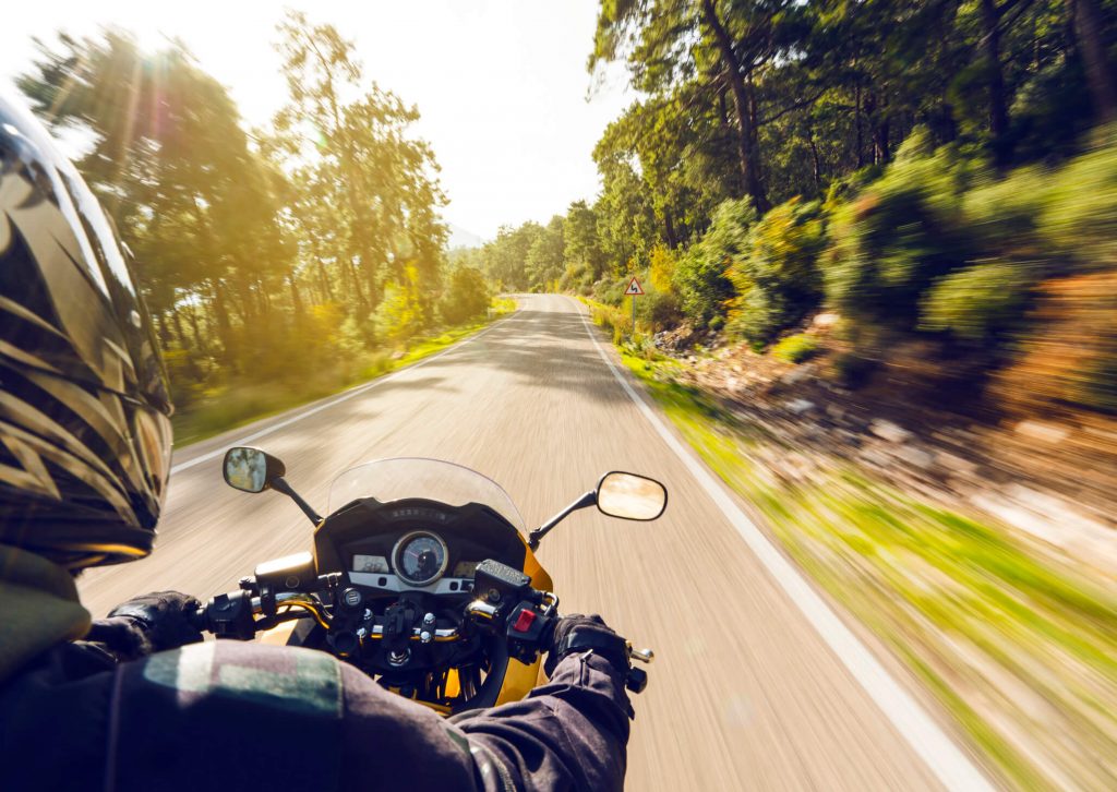 A motorcyclist driving down a road