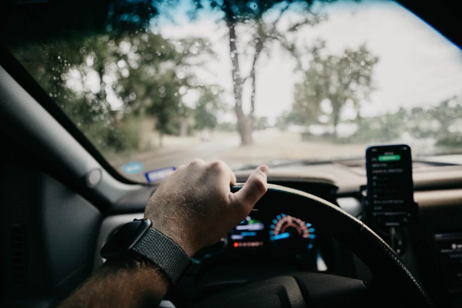 A hand on a car steering wheel