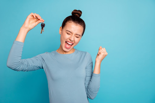 a young woman holding some keys excitedly