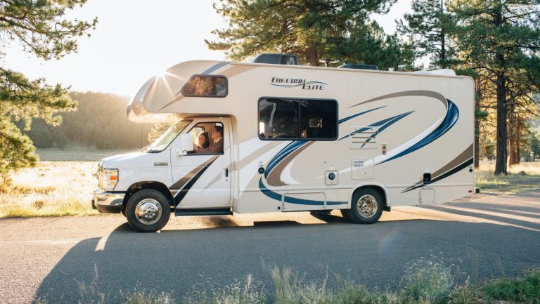 A man and woman driving in an RV.