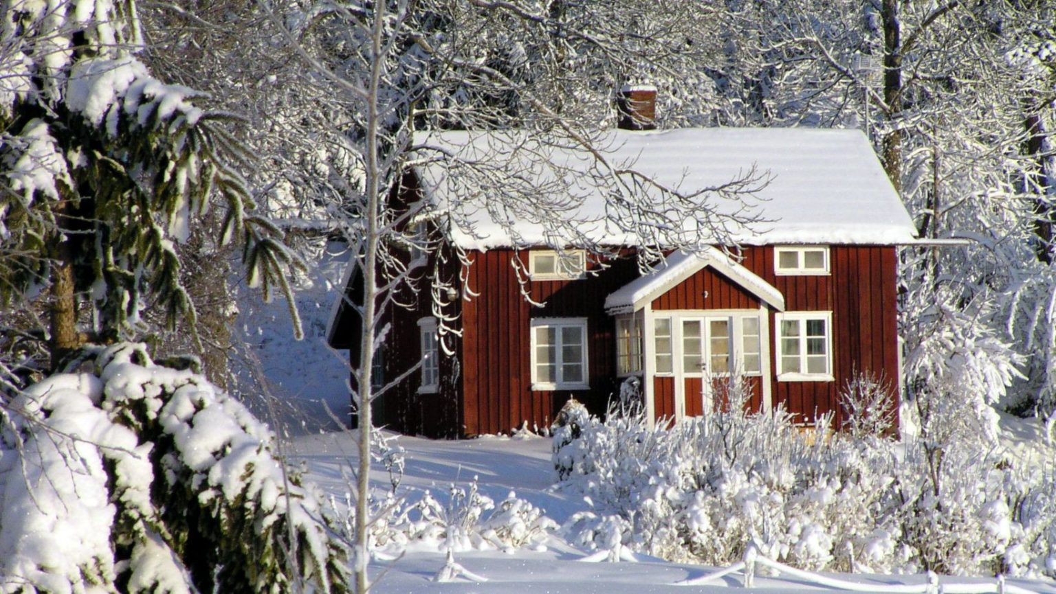 a red cottage with snow all around