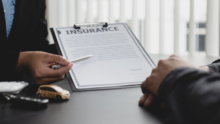 Someone using a pen to point to an insurance form.