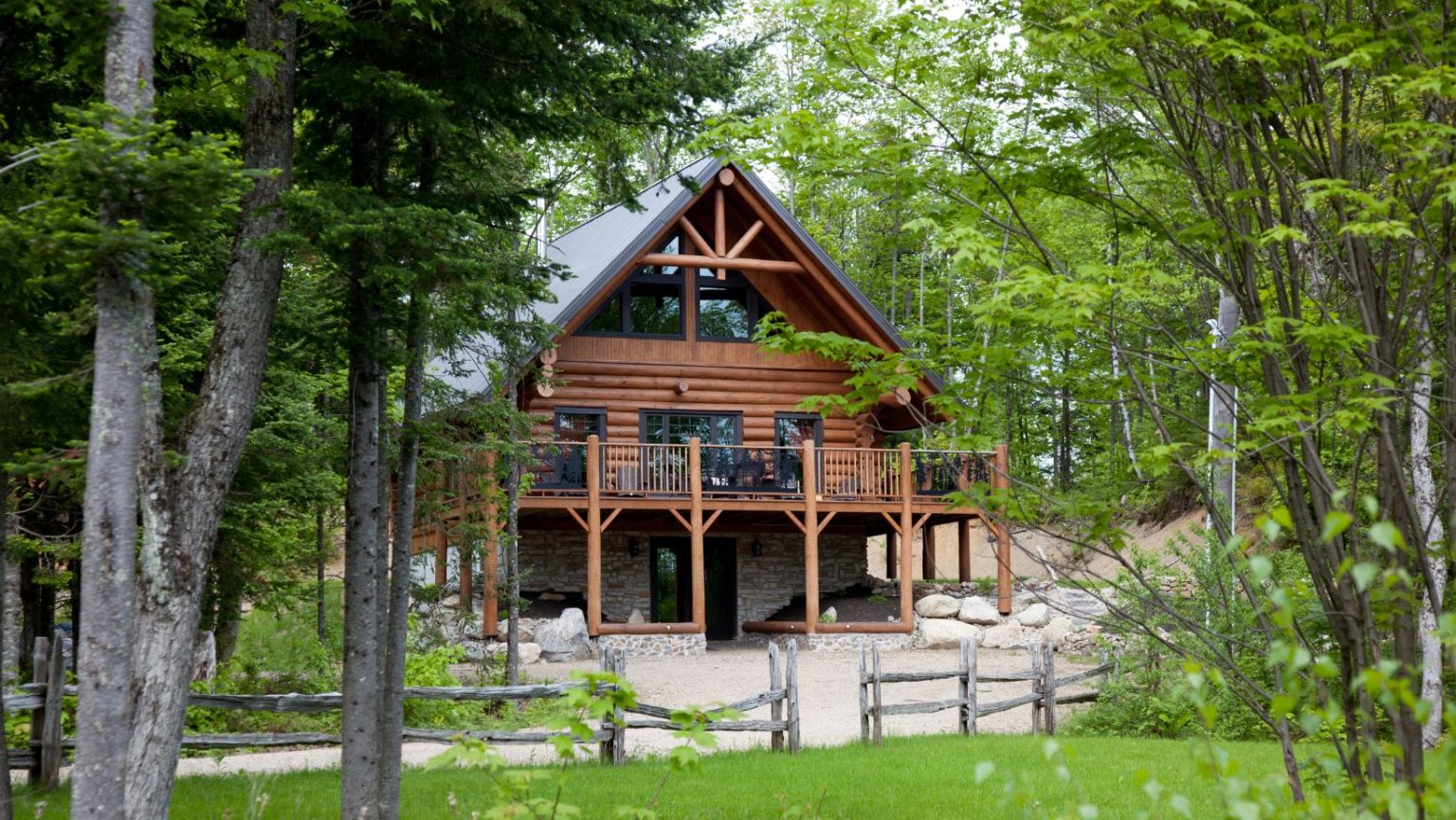 A wood cottage surrounded by trees.