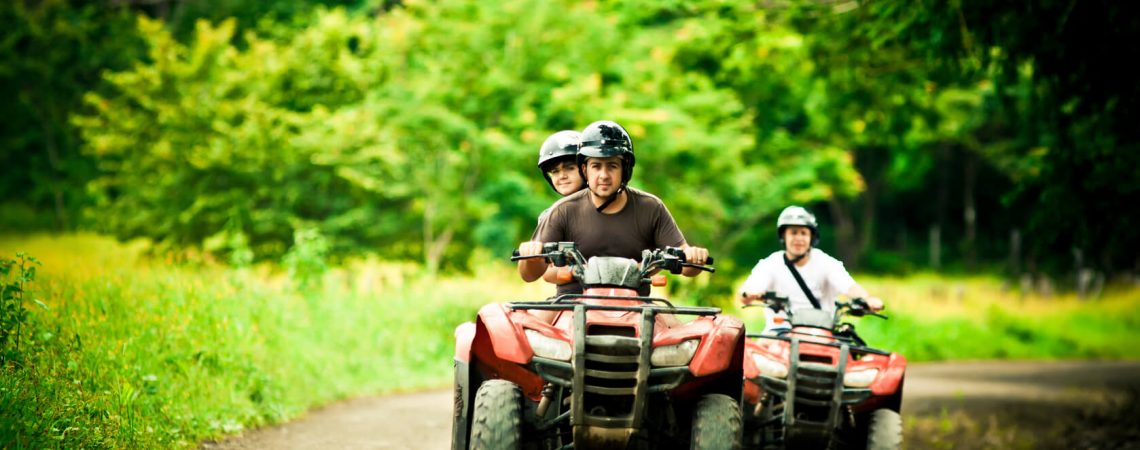 Two ATV riders with one passenger.