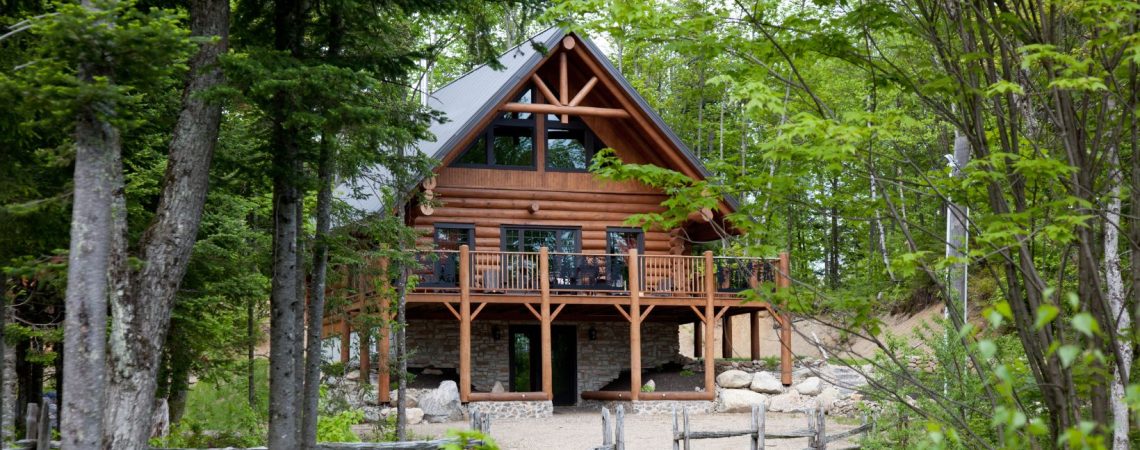 A wood cottage surrounded by trees.