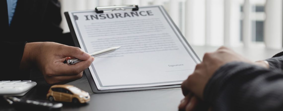 Someone using a pen to point to an insurance form.