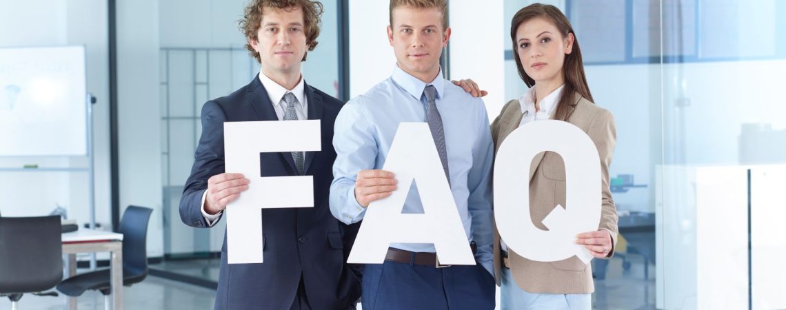 Three people holding a letter that says FAQ.