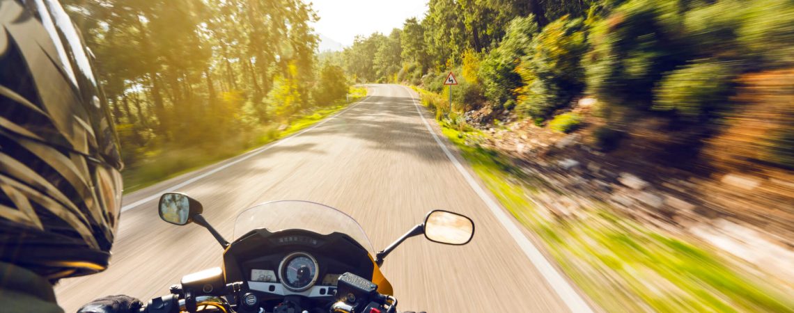 A motorcyclist driving down a road