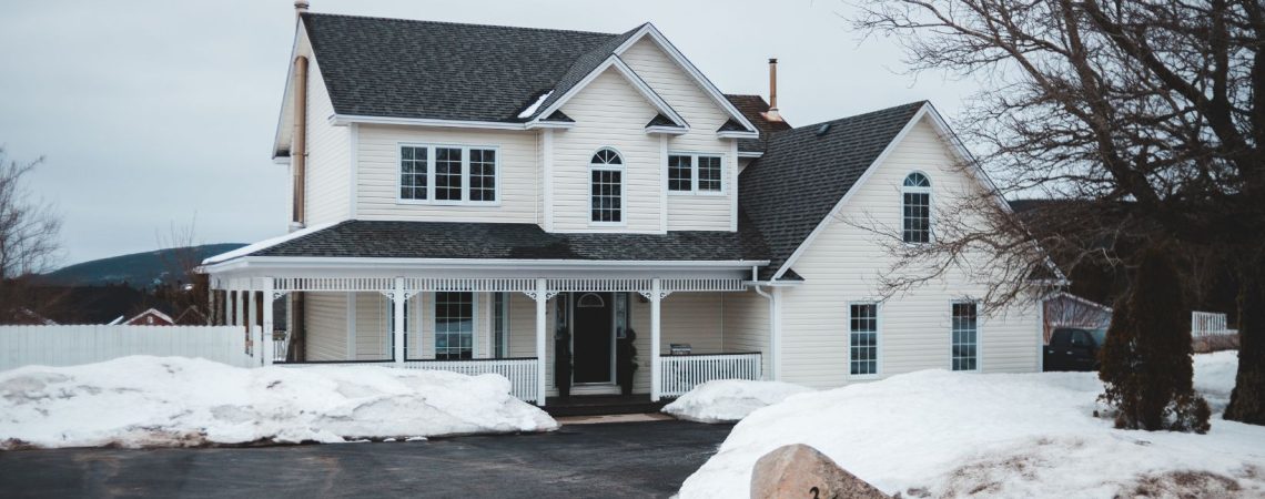 Prepare Your Home for Winter A white home in winter with snow surrounding it.