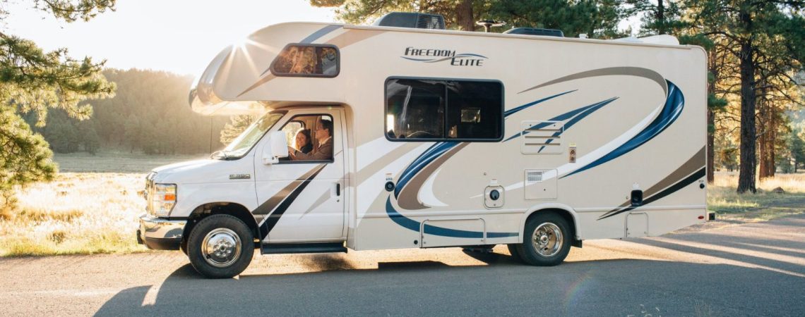 A man and woman driving in an RV.