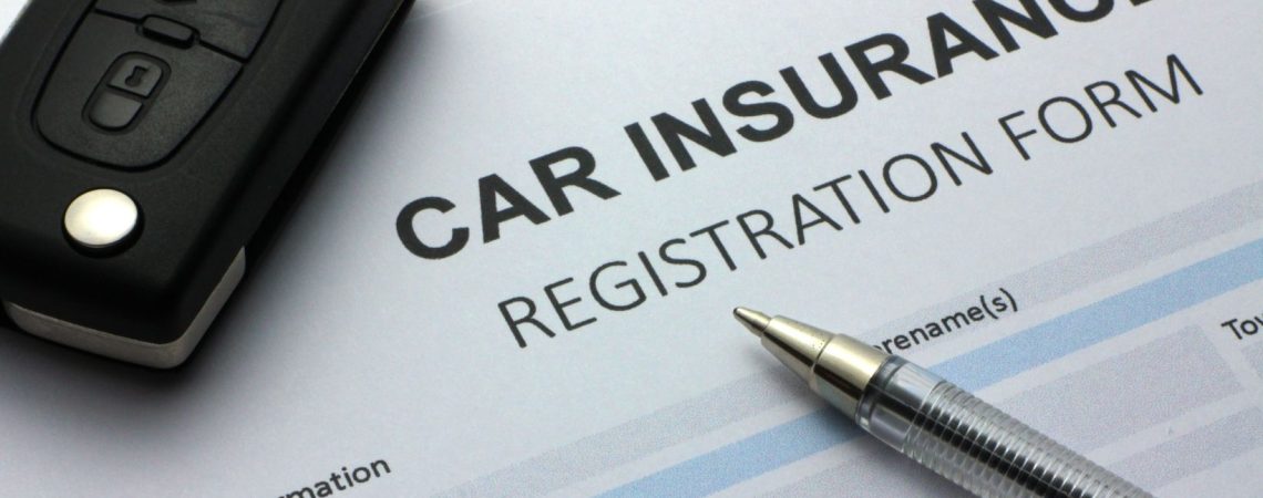 a car insurnace registration form with a pen and car key on top.