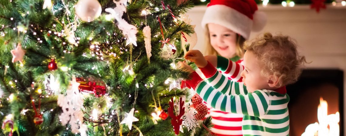 Two kids hanging an ornament