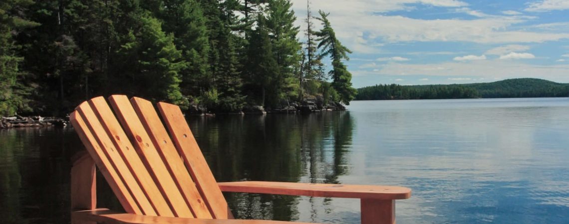 A chair on a deck at a cottage.