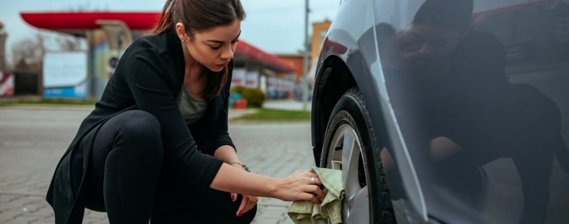 A woman looking at her car tire