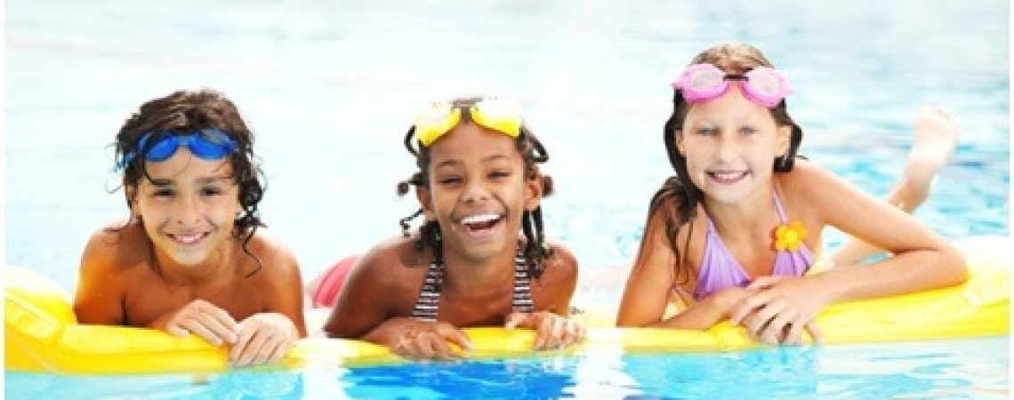 Three children swimming in a pool.