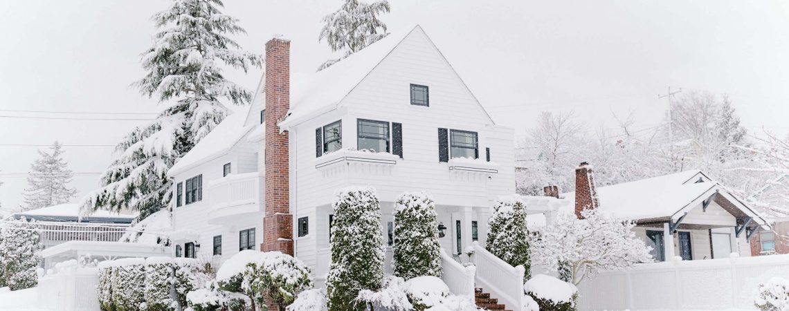A white house in the winter surrounded by snow