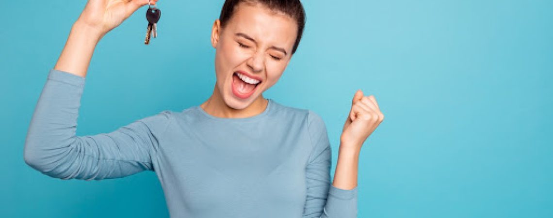 a young woman holding some keys excitedly