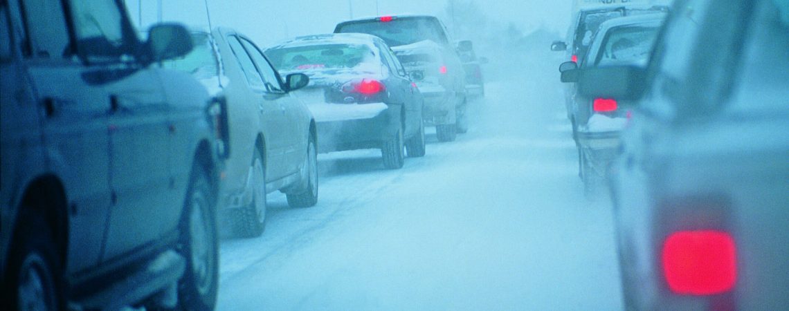 Various cars driving on a wintery road.